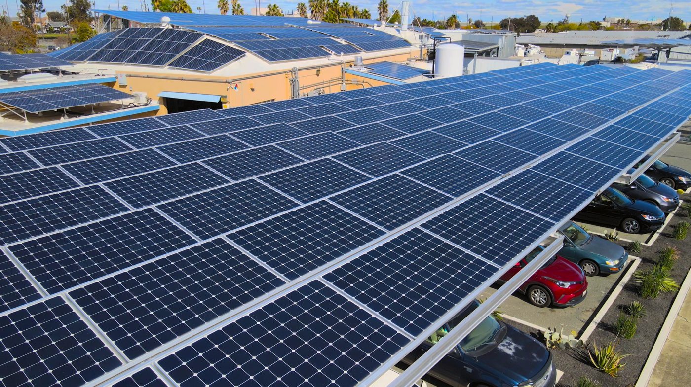 Aerial view of solar panels covering the roof and parking area at Ramar Foods’ headquarters in Pittsburg, California