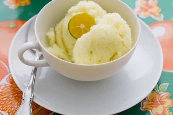 Calamansi sorbet in a white cup, topped with a calamansi half