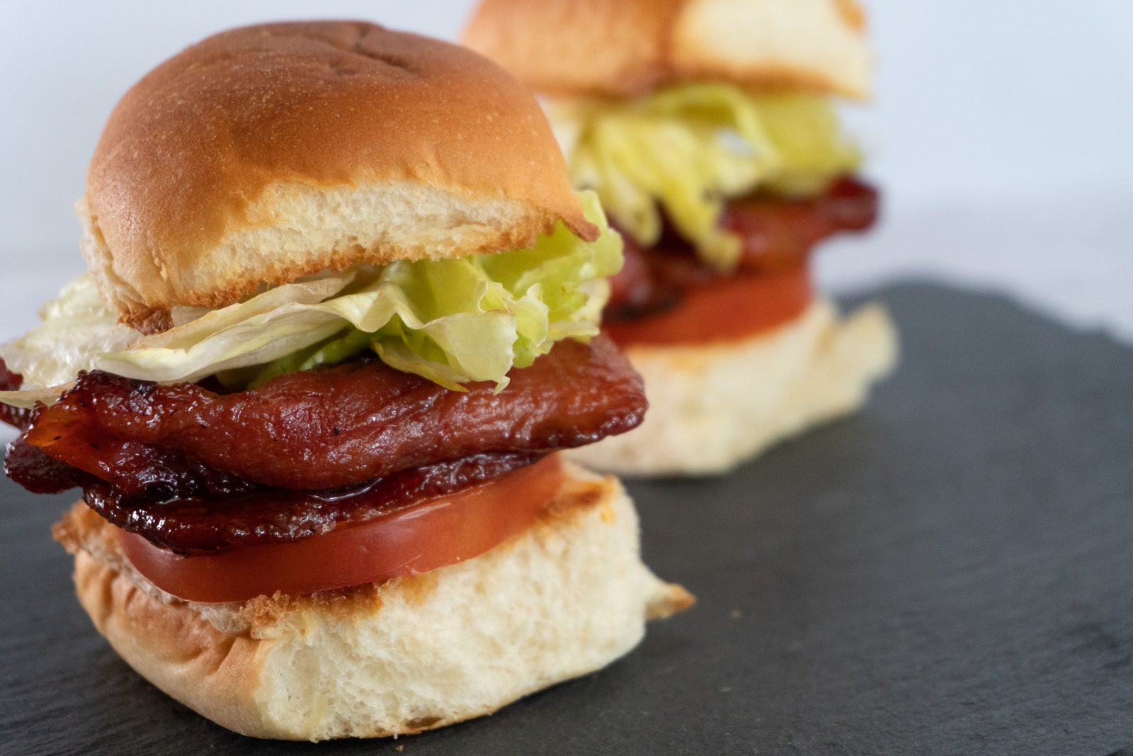 Pork tocino sliders with lettuce and tomato on soft buns