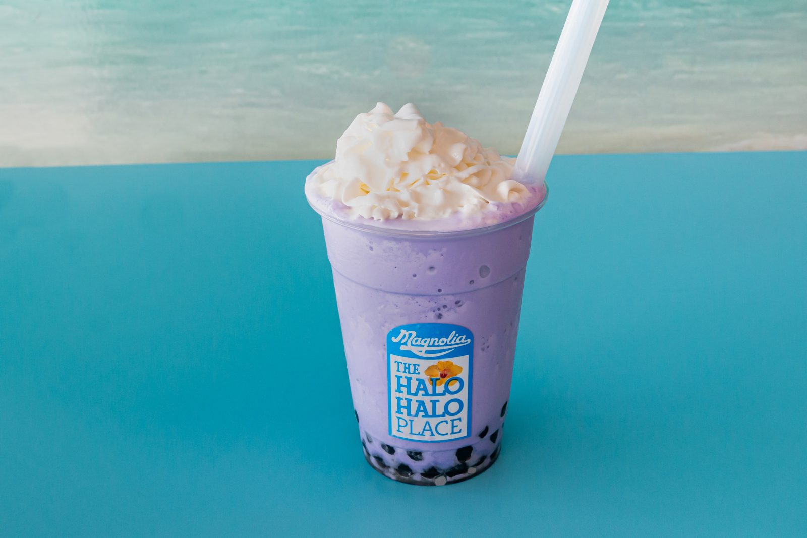 An ube milkshake with boba and whipped topping
